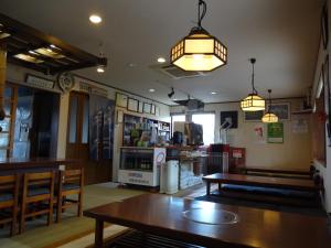 un restaurant avec une table, des chaises et des lumières dans l'établissement Nagomi-tei, à Hakuba