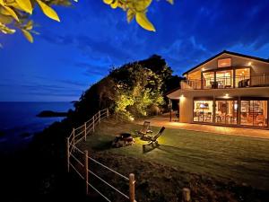 una casa con vistas al océano por la noche en UMIBE IseShima en Shima