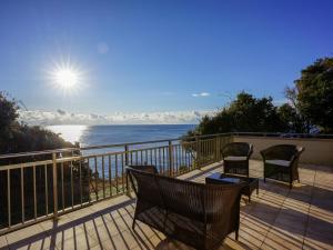 a balcony with chairs and a view of the ocean at UMIBE IseShima in Shima