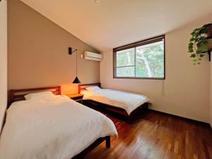 sypialnia z 2 łóżkami i oknem w obiekcie UMIBE IseShima w mieście Shima