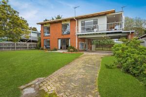 a brick house with a balcony and a yard at Hiddensee in Cowes