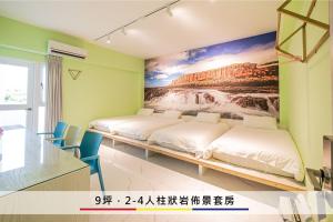 two beds in a room with a painting on the wall at 蒙德里安山水民宿 in Magong