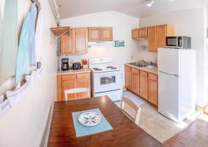 a kitchen with a wooden table and a white refrigerator at Downtown Apartments in Bar Harbor in Bar Harbor