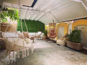 a porch with a swing and chairs and plants at Casa Beach in Ravda