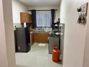 una pequeña cocina con fogones y nevera. en Champions Chill Suite en Eldoret