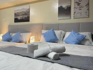 1 dormitorio con 2 camas y almohadas azules en Serin Tagaytay Staycation, en Tagaytay