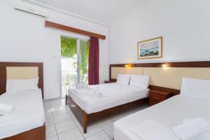 a hotel room with two beds and a window at Chrissafis Hotel in Panagia