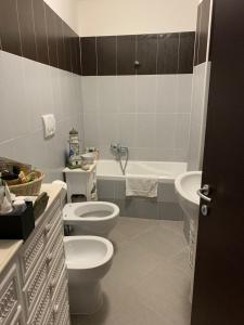 La salle de bains est pourvue de 2 toilettes, d'un lavabo et d'une baignoire. dans l'établissement Eve Home Suite Home, à Nettuno
