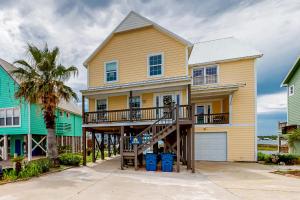 una gran casa amarilla con porche y garaje en Lemon Drop Lagoon, en Gulf Shores