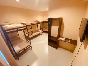 Cette petite chambre comprend plusieurs tables et un réfrigérateur. dans l'établissement Claytown Pension House, à Dumaguete