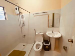 La salle de bains est pourvue de toilettes et d'un lavabo. dans l'établissement Claytown Pension House, à Dumaguete
