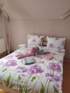 uma cama com flores cor-de-rosa num quarto em Карпати котедж Анастасія em Skole