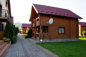 drewniany dom z ceglaną ścieżką obok niego w obiekcie GorodOk w mieście Migowo