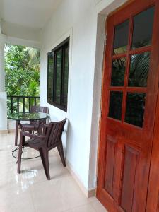 a door to a porch with a table and a chair at Sabinas Goa in Saligao