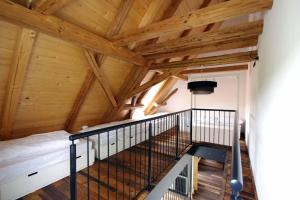 an attic room with a staircase and wooden ceilings at Ochsenhof in Mainleus