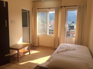 una camera da letto con un letto e una grande finestra di Beli Guest House a Pokhara