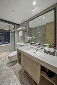 a bathroom with a sink and a toilet and a mirror at Shenzhen FY Hotel in Shenzhen