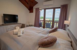 a bedroom with a large bed with a large window at Tri Duby Golf Apartments in Badín