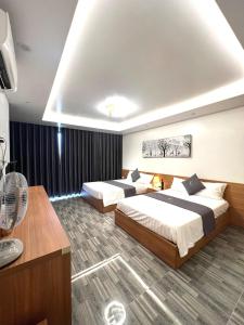 een hotelkamer met 2 bedden en een ventilator bij An Cường Hotel in Sầm Sơn