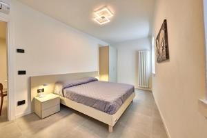 um pequeno quarto com uma cama e uma mesa de cabeceira em ApartmentsGarda - Residenza Mercanti em Garda