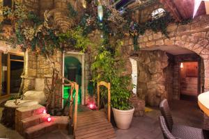 een kamer met een stenen muur met een houten trap en planten bij Forellenhof Rössle Hotel & Restaurant in Honau