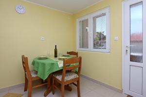 ein Esszimmer mit einem Tisch, Stühlen und einer Uhr in der Unterkunft Apartments and rooms with parking space Vrbnik, Krk - 5299 in Vrbnik