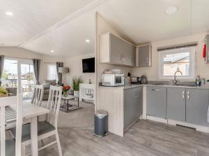 a kitchen with a table and a microwave at The Cotswold Holiday Lodge in Evesham