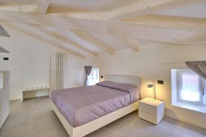 um quarto com uma cama grande e uma janela em ApartmentsGarda - Residenza Mercanti em Garda