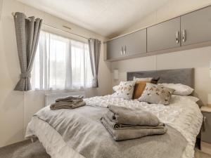 Un pat sau paturi într-o cameră la The Cotswold Holiday Lodge