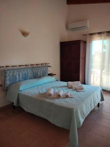 a bedroom with a bed with towels on it at Agriturismo i doni del mandorlo in Alghero