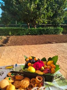 a tray of fruits and vegetables on a table at Agriturismo i doni del mandorlo in Alghero
