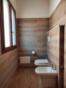 a bathroom with two toilets and a sink and a window at Agriturismo i doni del mandorlo in Alghero