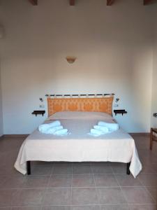 a bedroom with a bed with towels on it at Agriturismo i doni del mandorlo in Alghero