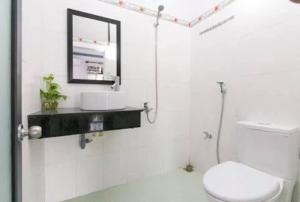 bagno con servizi igienici, lavandino e specchio di Hai Dang Homestay a Hoi An