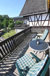 a patio with a table and chairs on a deck at Gästehaus Achenbach in Biedenkopf