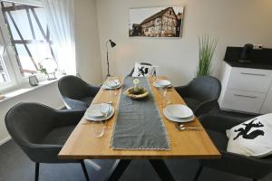 a wooden table with chairs around it with a table cloth at Gästehaus Achenbach in Biedenkopf