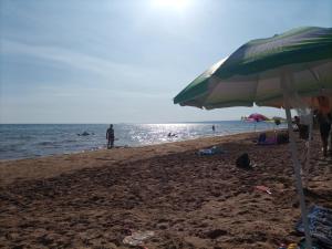 una playa con sombrilla y gente en el agua en Sabbiad'oro, en Santa Maria del Focallo