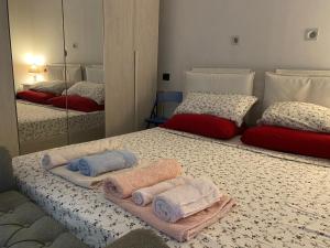 a bedroom with two beds with towels and a mirror at Eve Home Suite Home in Nettuno