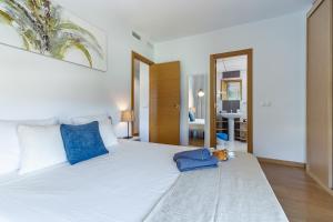 a bedroom with a white bed with a teddy bear on the floor at Valparaiso Premium Playa Apartment with parking in Málaga