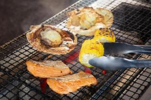 a grill with a spatula cooking food on it at Hotel Resol Hakodate in Hakodate