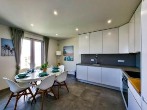 a kitchen with a table and chairs in a room at FLH Vilamoura Duplex with Terrace & Pool in Vilamoura