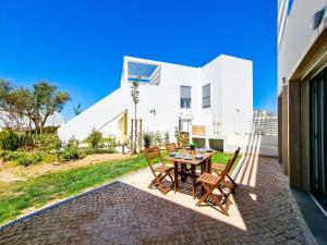 a patio with a table and chairs in front of a white house at FLH Vilamoura Duplex with Terrace & Pool in Vilamoura