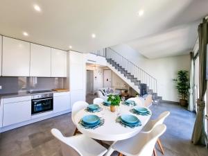 a kitchen and dining room with a white table and chairs at FLH Vilamoura Duplex with Terrace & Pool in Vilamoura
