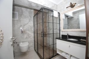 a bathroom with a shower and a toilet and a sink at Raymar Hotels Muğla in Muğla