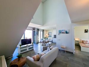 a living room with white furniture and a tv at FLH Vilamoura Duplex with Terrace & Pool in Vilamoura
