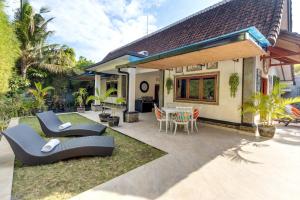 a house with a patio with chairs and a table at Villa Yati in Seminyak