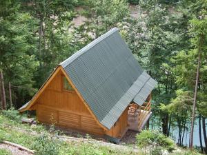 eine Hütte im Wald mit einem Metalldach in der Unterkunft Little Heaven Apartments in Jezdići