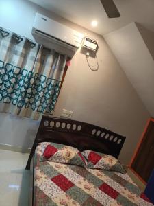 ADVIK HOMESTAYS في تيروباتي: غرفة نوم بسرير ومروحة سقف