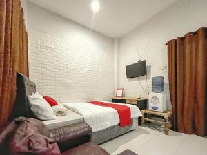 a bedroom with a bed and a tv in it at RedDoorz Syariah near Siloam Hospital Mataram in Mataram