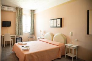 ein Hotelzimmer mit einem großen Bett in einem Zimmer in der Unterkunft Hotel Cala Di Seta in Calasetta
